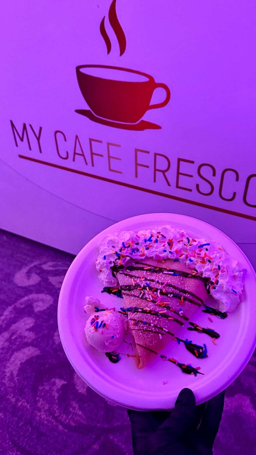Sprinkle-topped crepe with ice cream in front of the My Cafe Fresco logo