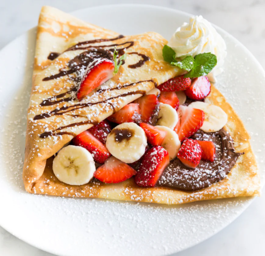 Nutella crepe with strawberries, banana, and whipped cream
