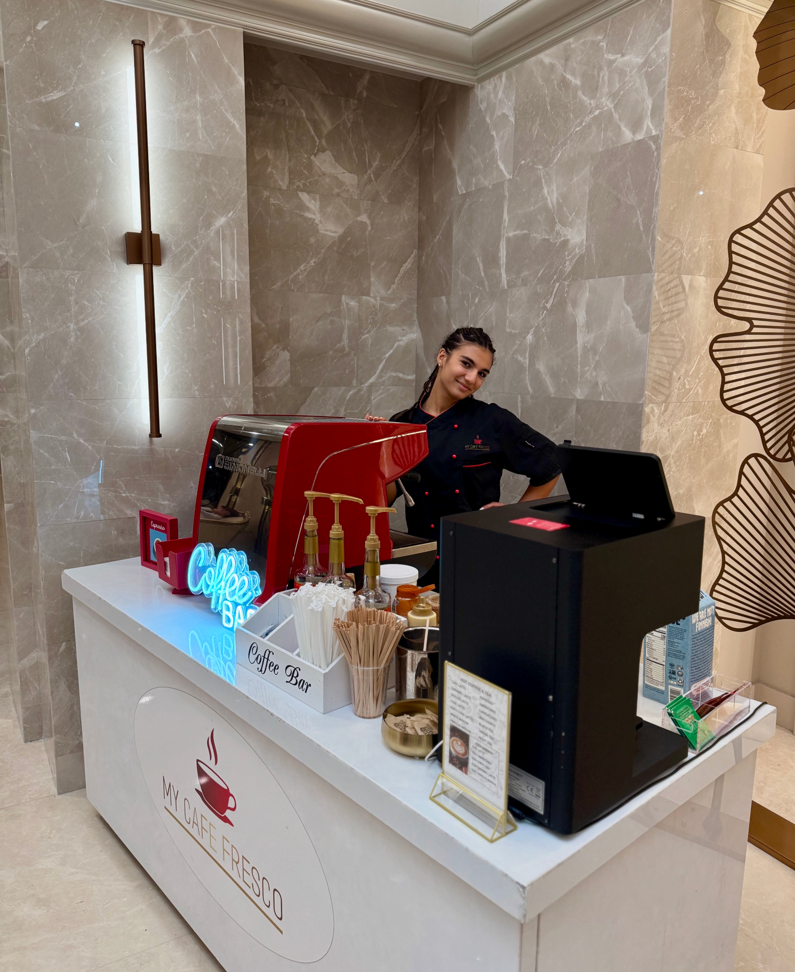 My Cafe Fresco barista behind the espresso cart at a marble-lobby event