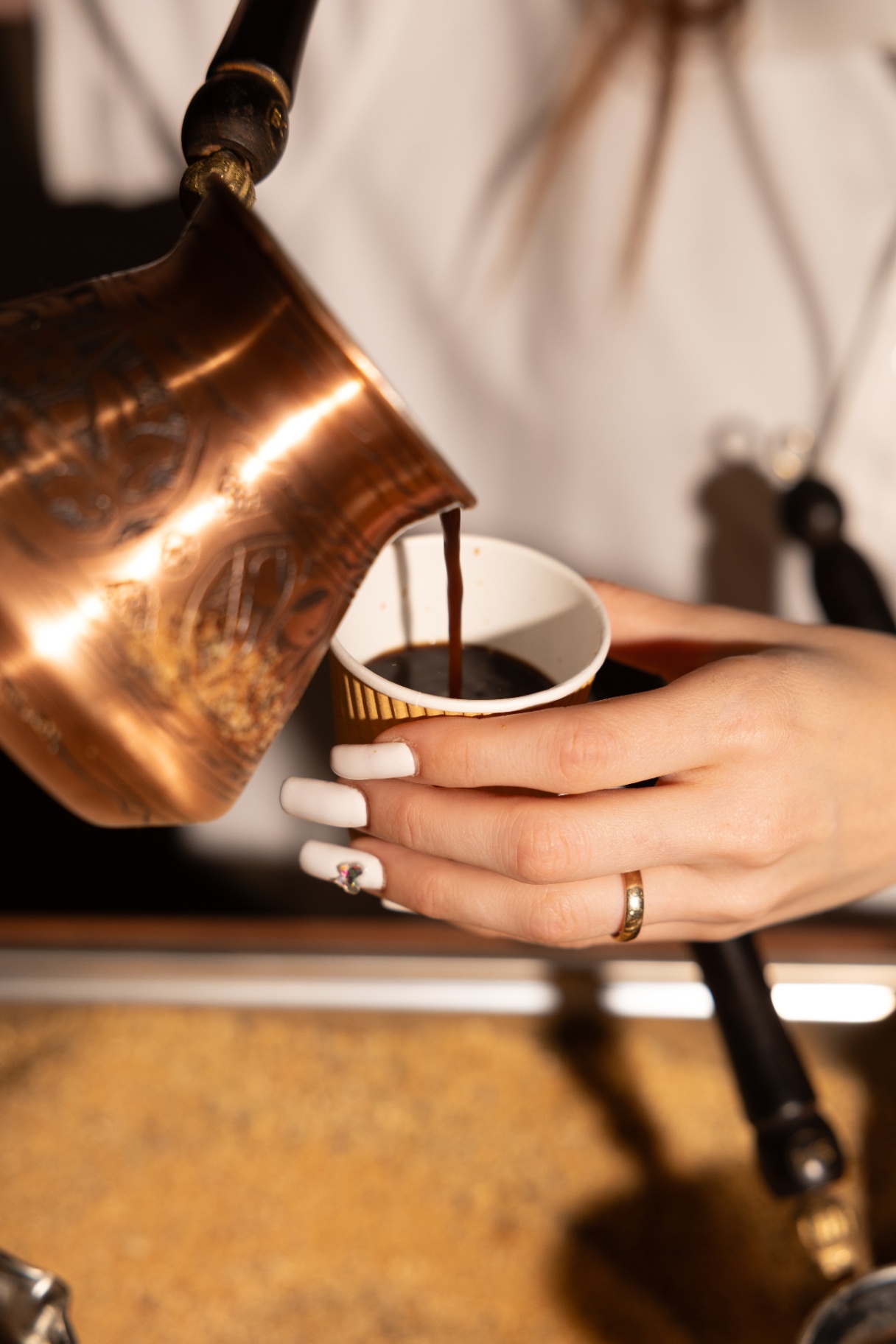 Close-up of Armenian coffee being poured from a copper jazzve into a paper cup