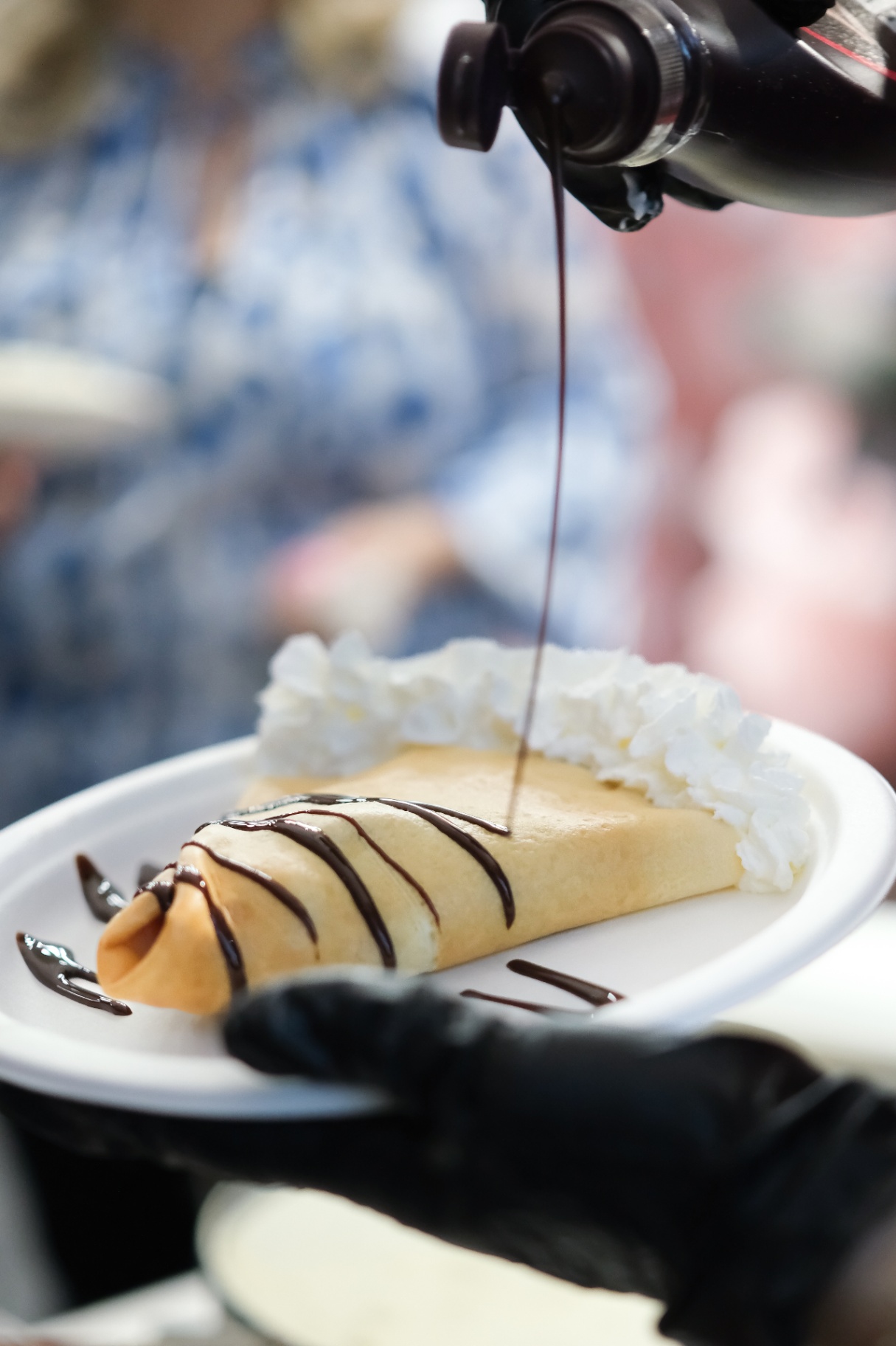 Sweet crepe with chocolate drizzle and whipped cream
